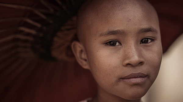 Young Buddhist monk gathering alms. Mandalay, Myanmar